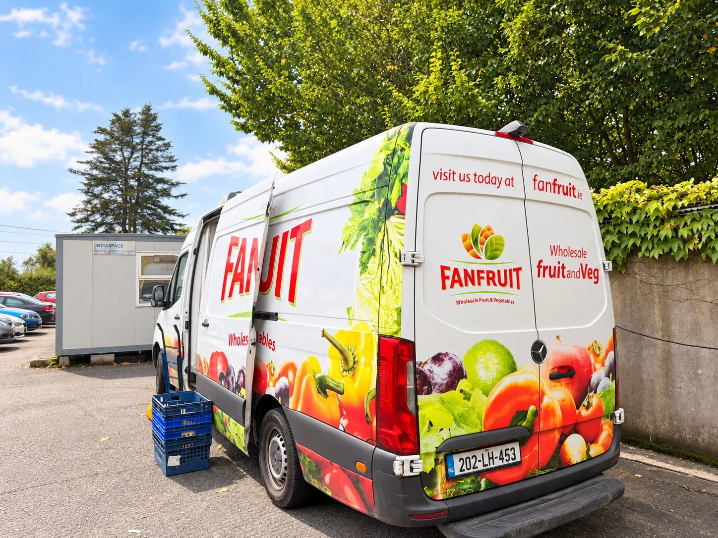 Fanfruit refrigerated delivery van parked with its side door open and crates ready to load